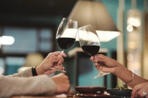 Mann und Frau die mit einem Glas Wein anstoßen